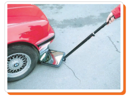 Search mirror being used to check under a car